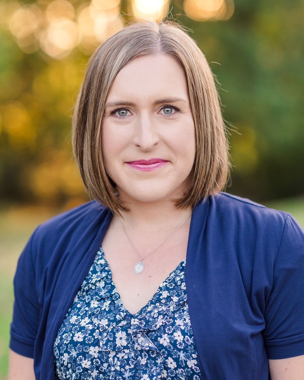 headshot of woman wearing blue flower dress in golden hour light with a Cranberry Township, PA newborn photographer