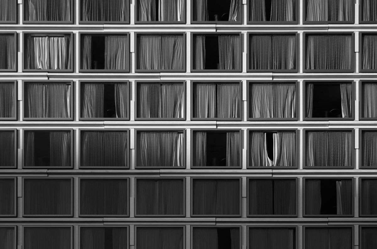 Symmetrical view of building windows with curtains, captured by photographer Sandeep Gajula