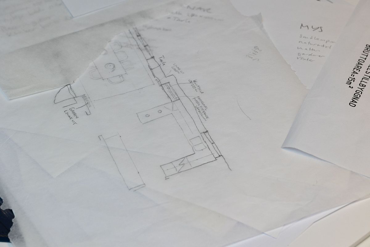 Skisspapper i lager med handritad plan och anteckningar &ndash; inredningskoncept under utveckling.